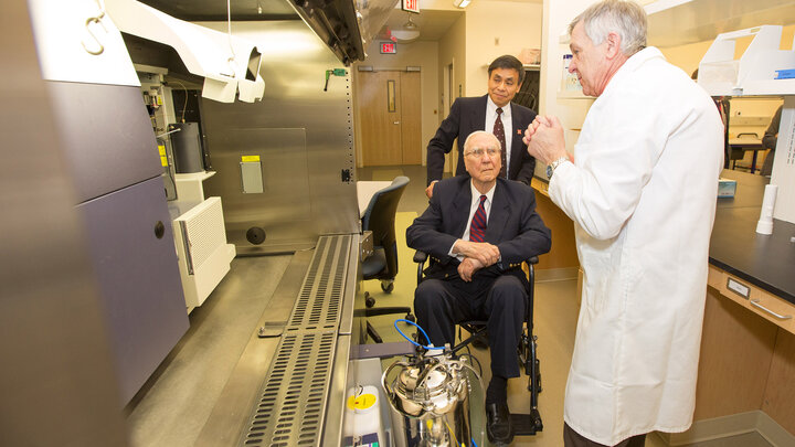 Ken Morrison, seated, and Charles Wood listen as Charles Kuszynski describes the new equipment and labs in the addition to the Morrison Life Sciences Research Center. Morrison was on hand to help cut the ribbon on the new addition.